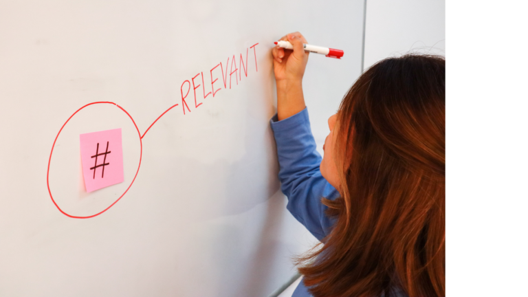 A woman strategizing hashtag approaches for effective social media engagement on a whiteboard.