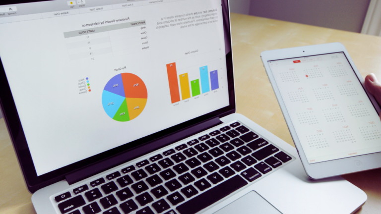 A laptop displaying colorful pie and bar charts for social media analytics next to a tablet with a monthly calendar view, representing tools used in a Buffer Content Scheduling Guide for effective social media management.