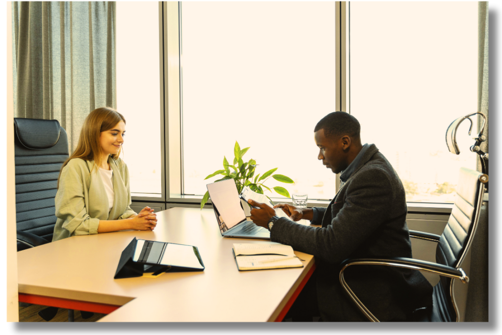 An image of a professional interview in progress, with a gentleman interviewer attentively listening to a lady candidate as she confidently discusses her experiences.