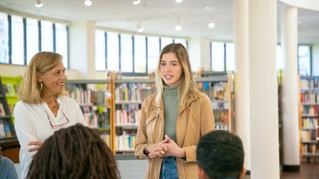 A woman presenting SEO Tips for Beginners to an engaged audience in a library, symbolizing interactive and educational communication.