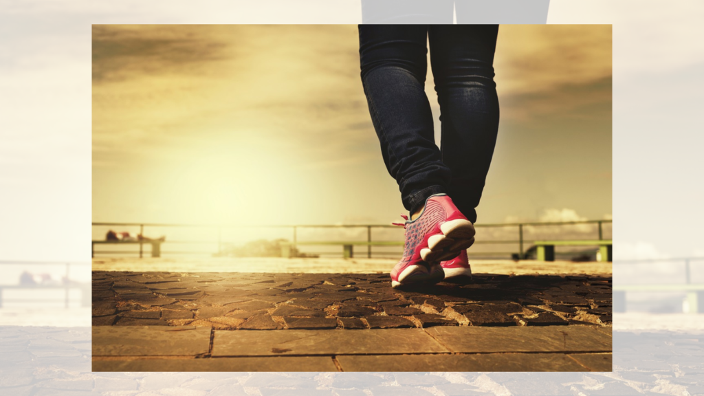 A person wearing vibrant red sneakers takes a step on a textured pavement, symbolizing the active movement captured by walking reward apps.