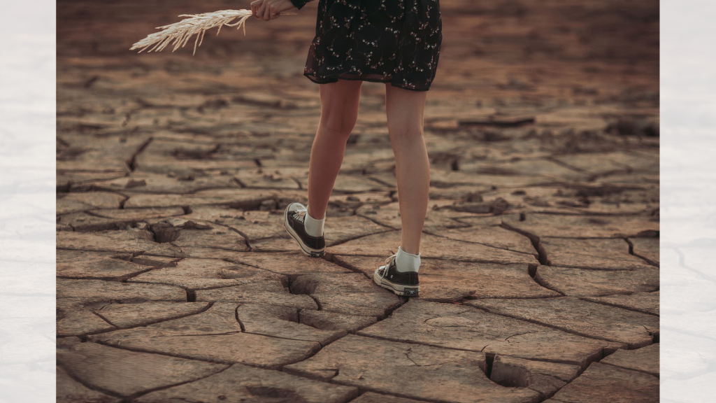 A person strides across a cracked earth surface, embodying the eco-conscious spirit of walking reward apps that promote healthy living and sustainability.